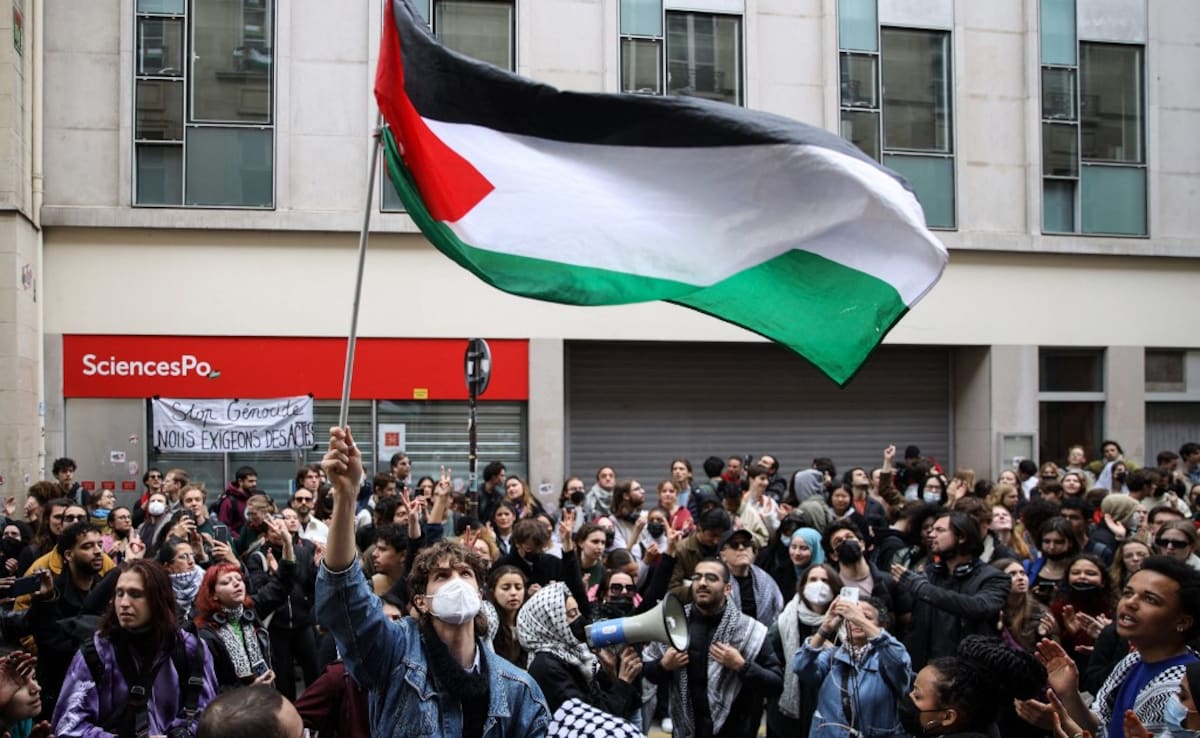 A protester waves a Palestinian flag during a demonstration in front of the Institute of Political Studies (Sciences Po Paris) occupied by students